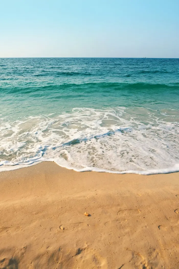 Sunset over the ocean from a tropical beach — the reward for smart travel budgeting