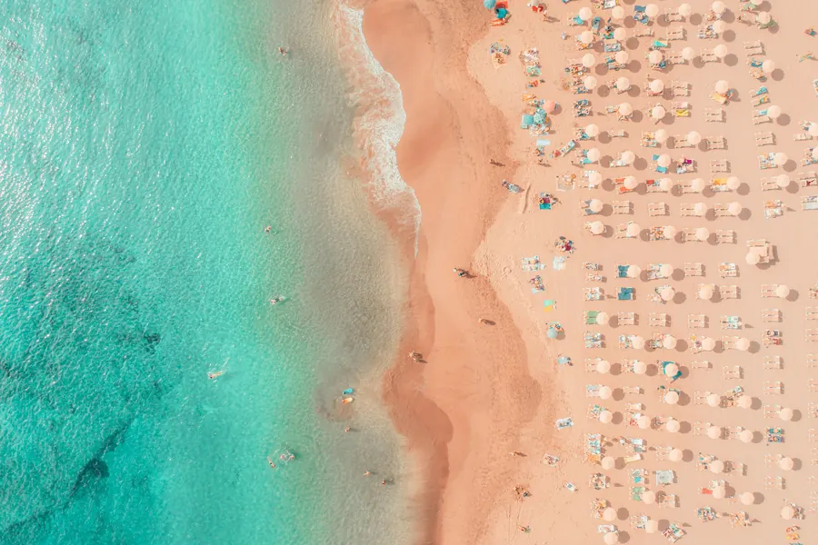 Crystal-clear turquoise water at a Caribbean island beach — the defining feature travelers compare when choosing between islands