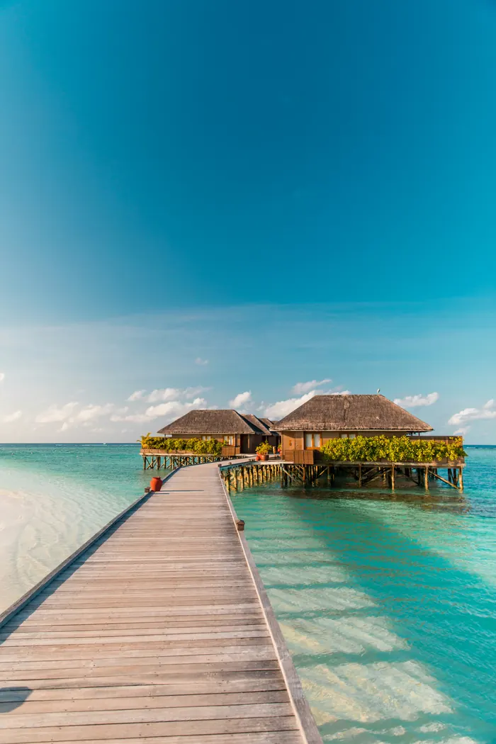 Aerial view of a Maldives resort island — the overwater-bungalow experience that defines both the Maldives and Bora Bora comparison